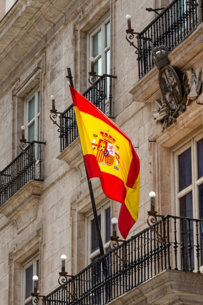 Edifício clássico com a bandeira espanhola hasteada. Sa Santy oferece serviço completo para seu Passaporte Espanhol