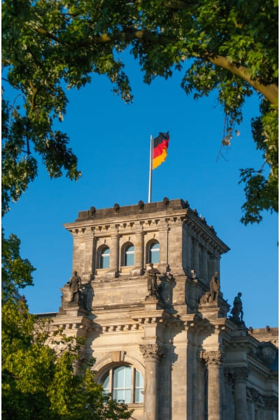 Edifício clássico com uma bandeira alemã hasteada. Cidadanias Alemãs é com a Santy
