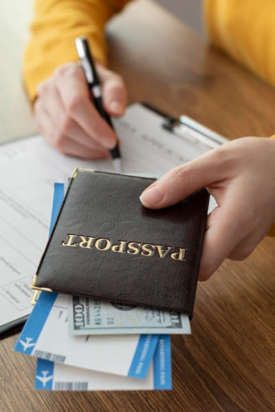 Uma pessoa segura os passaportes enquanto faz uma anotação em uma prancheta. A Santy Assessoria Consular auxilia você em Passaportes.
