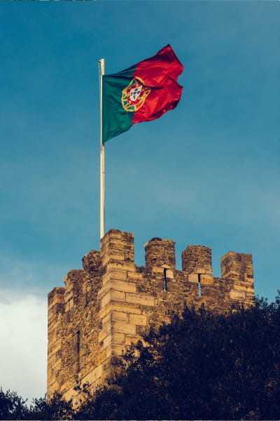 Edifício clássico português com a bandeira portuguesa hasteada.